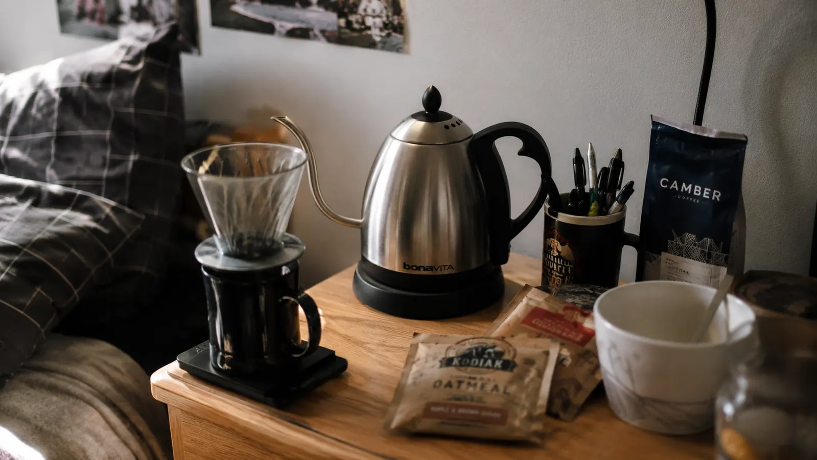 Hamilton Beach kettle sitting on a small tray next to instant oatmeal and a pour-over coffee dripper in a dorm room