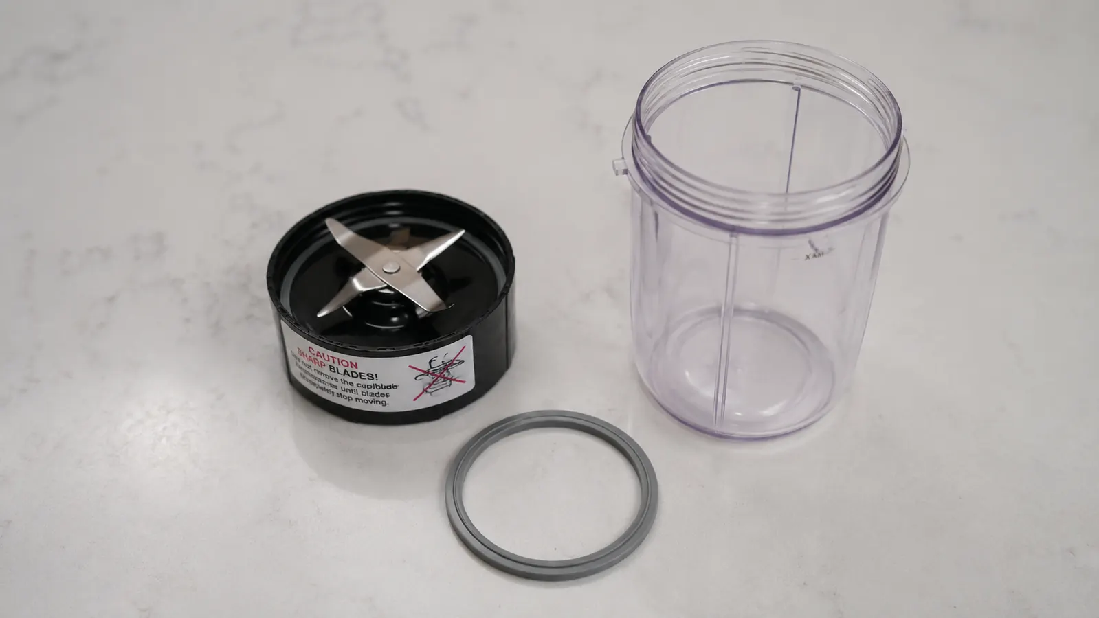 Close-up of Magic Bullet blade assembly and gasket ring separated on a counter for inspection